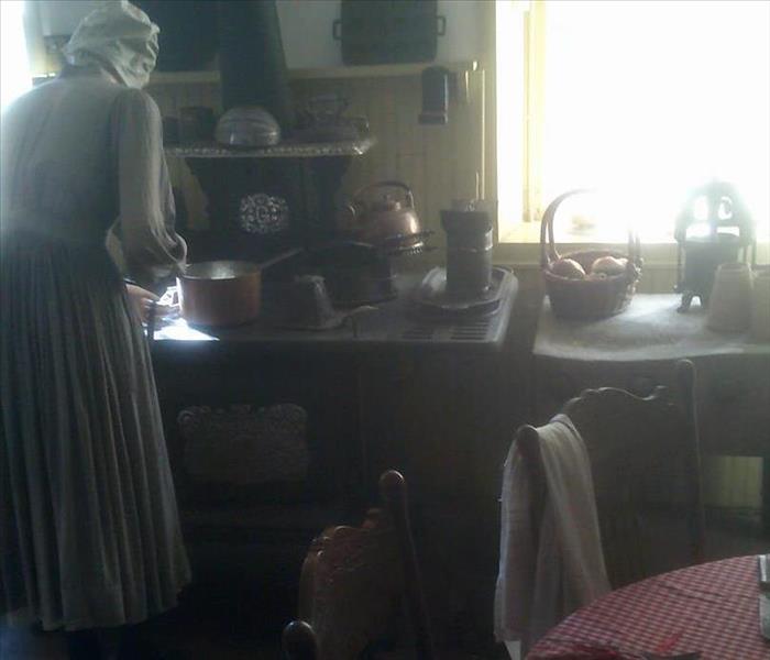 Historic kitchn replicated to include old world kitchen set up with containers, sink & manequin dressed in period time dress